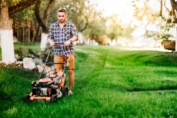 man mowing the lawn for yard maintenance
